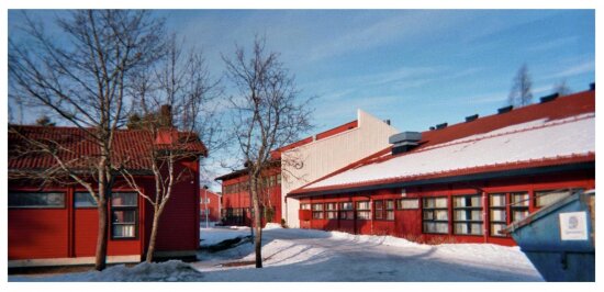 Rød skolebygning, blå himmel, snø og trær
