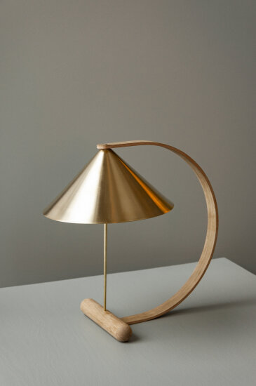 En bordlampe i tre og messing - av utseende kan lampen minne om en spent bue. Derav navnet Spenn.
