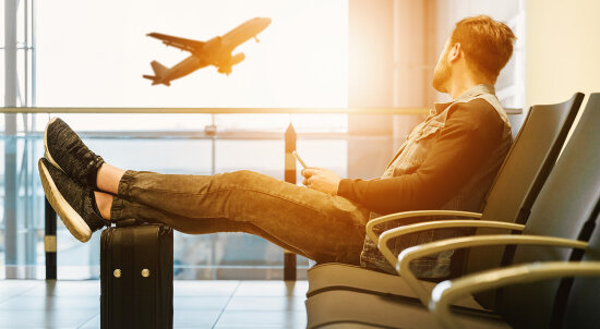 En mann på flyplass ser ut på et fly utenfor vinduet