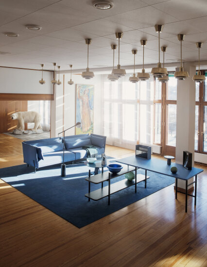 Ambassaden i Stockholm fylt med en blå sofa og blått teppe, begge av norsk design. Det kommer lys inn av store vinduer og står en utstoppet isbjørn i hjørnet. Arkitekturen er syttitalls.